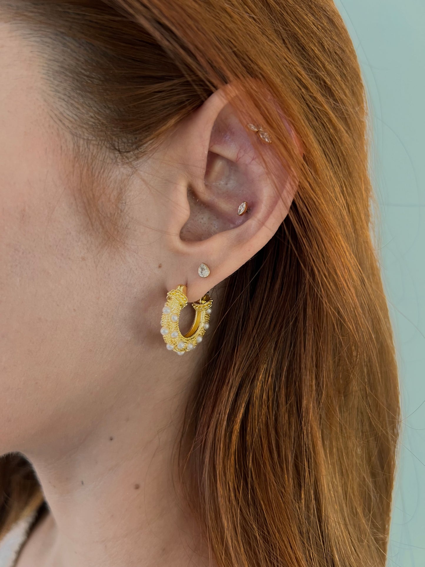 Pendientes dorados forma redonda.